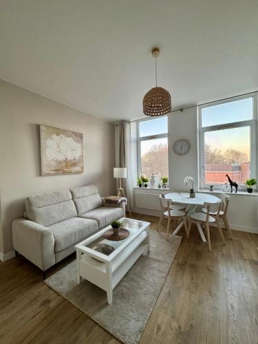 un salon avec un canapé et une table dans l'établissement Le National 2 Appartement centre ville avec Parking privé, à Tourcoing