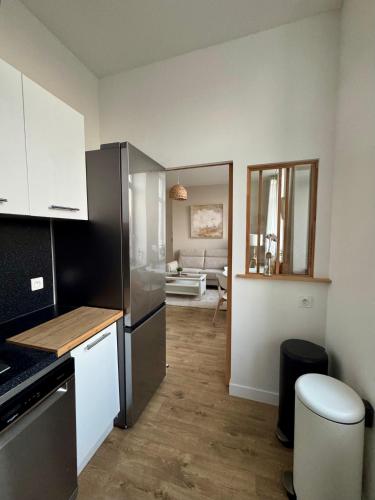 une cuisine avec un réfrigérateur en acier inoxydable et un salon dans l'établissement Le National 2 Appartement centre ville avec Parking privé, à Tourcoing