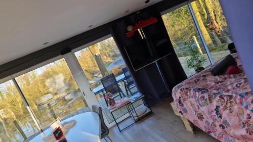 a bedroom with a bed and a large window at Ô Chalet in Beloeil