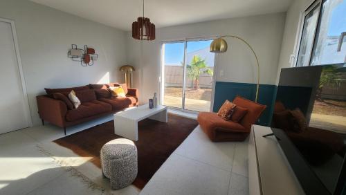 a living room with a couch and a table at La Pétillante in Vaux-sur-Mer