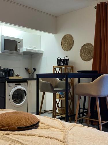 une cuisine avec une table et une machine à laver dans l'établissement Nouveau ! Magnifique Studio douillet & Tout confort - Parking - Wifi - Netflix -, à Wissembourg