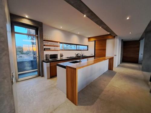 a kitchen with a counter and a large window at Arroyo Escondido-Luxe Oceanview Contemporary Home with all the Extras in Todos Santos