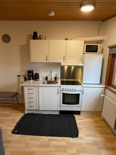 a kitchen with white cabinets and a stove and a sink at Cozy apartment in Tórshavn, Faroe Island with free parking. in Tórshavn