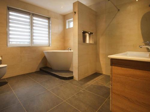 a bathroom with a tub and a toilet and a sink at Villa Seeblick in Lychen in Lychen