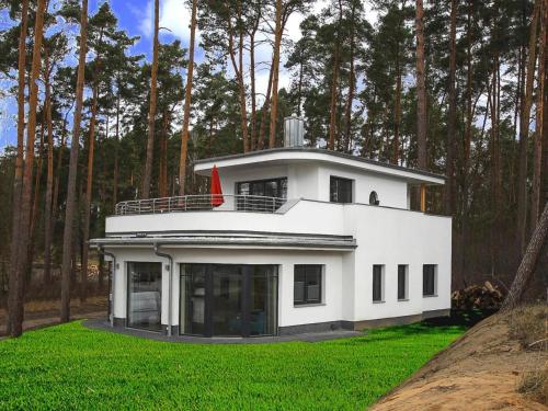 a white house with a red flag on top of it at Villa Seeblick in Lychen in Lychen
