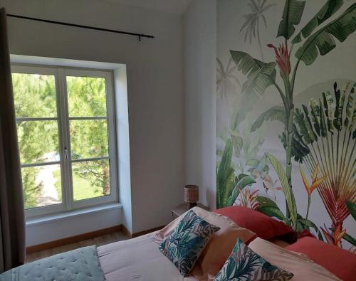 a bedroom with a bed and a window with a mural at Le Chai de Villiers in Villiers