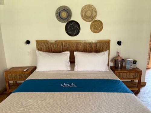 a bedroom with a bed with plates on the wall at NENA BEACH CLUB & HOTEL in Baru