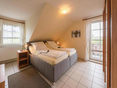 a bedroom with a bed and a window at Ferienwohnungen in Friedrichkoog-Spitze in Friedrichskoog-Spitz
