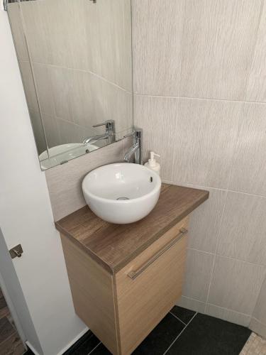une salle de bain avec un lavabo blanc et un miroir dans l'établissement Studio lumineux proche de Paris, à Arnouville-lès-Gonesse
