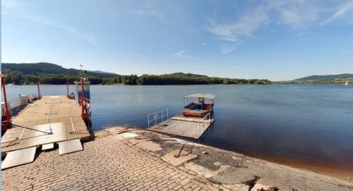 a boat is docked at a dock on a lake at Apartmán Juli in Horní Planá