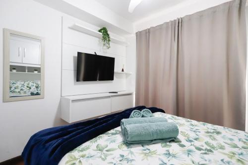 a bedroom with a bed with a television on a wall at SanLoft Expo Inn Tietê 05 - Preferido! in Sao Paulo