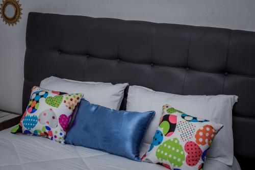 a group of pillows sitting on top of a bed at Monitaet Apartments in Lusaka