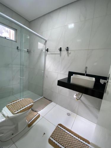 a bathroom with a shower and a toilet and a sink at Casa Essenza in Mulungu