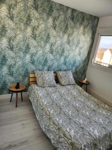 une chambre avec un lit et une peinture murale dans l'établissement Appartement cosy, à Vittel
