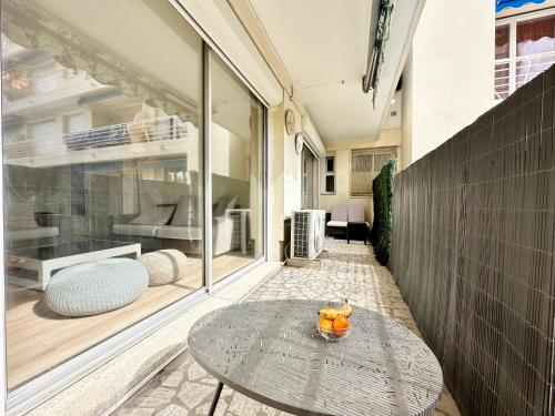 une table en verre assise sur une terrasse avec une fenêtre dans l'établissement 3P refurbished Cannes Palm Beach 200 m from the beaches, à Cannes