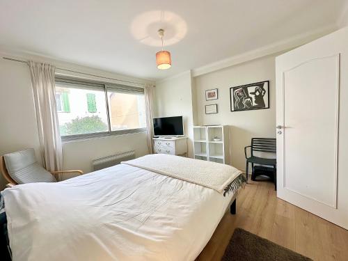 une chambre avec un lit, une télévision et une fenêtre dans l'établissement 3P refurbished Cannes Palm Beach 200 m from the beaches, à Cannes
