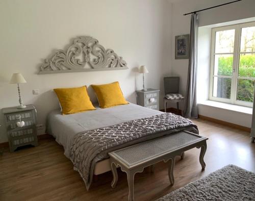 a bedroom with a large bed with yellow pillows at Le Chai de Villiers in Villiers