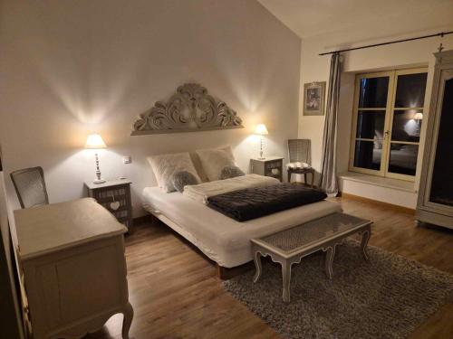 a bedroom with a large bed and a table at Le Chai de Villiers in Villiers