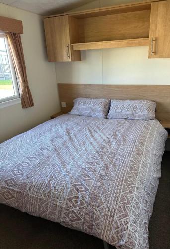 a bedroom with a large bed with a wooden headboard at Covesea View Silver Sands in Lossiemouth