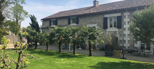 a house with palm trees in front of it at Le Chai de Villiers in Villiers