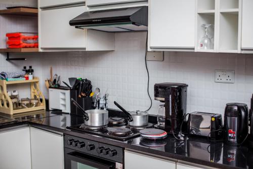 a kitchen counter with pots and pans on a stove at Monitaet Apartments in Lusaka
