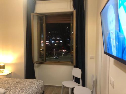 a room with a window with a tv and two chairs at B&B Rome Vatican Residence in Rome