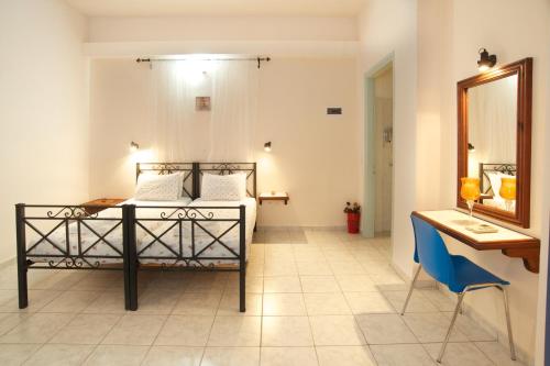 a bedroom with a bed and a desk and a mirror at Nostos in Mousata