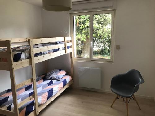 ラ・ボールにあるMaison à 10mn à pieds de la plageのベッドルーム1室(二段ベッド、椅子、窓付)