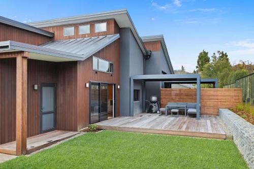 a house with a deck with a bench on it at Inn Sophia in Rotorua