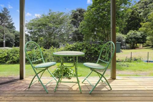 a table and two chairs sitting on a porch at Back of Beyond Cottage in Rotoiti