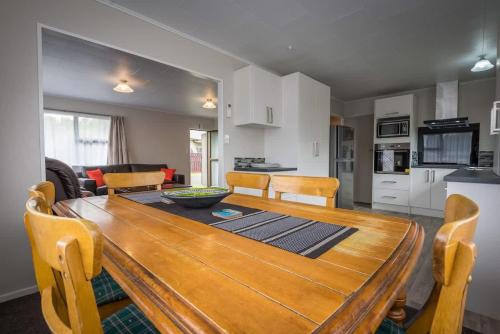 a kitchen and dining room with a wooden table and chairs at Beez Kneez in Rotorua