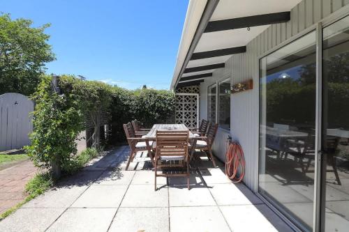 a patio with a table and chairs on the side of a building at Hannah's Bay Lakefront in Rotorua
