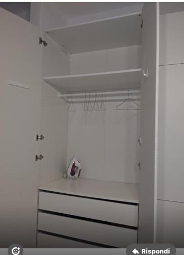 a kitchen with white walls and a white shelf at Leo&Franci in Legnano
