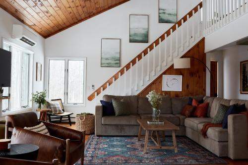 a living room with a couch and a staircase at Cozy Lux Mountain Lodge Hot Tub Mtn Views Skiing in Jewett