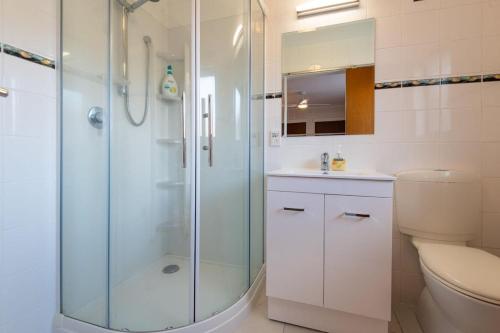une salle de bain avec une douche en verre et des toilettes dans l'établissement Central Hotspot, à Rotorua