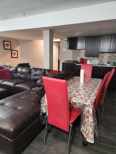 a living room with a couch and a table with red chairs at Serenity & memorable Cozy Lower Level Apartment Room in TownHouse Private Entrance in Gatineau