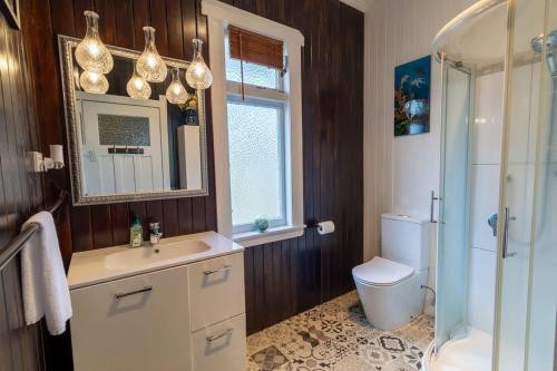 a bathroom with a sink and a toilet and a mirror at Central Villa in Rotorua