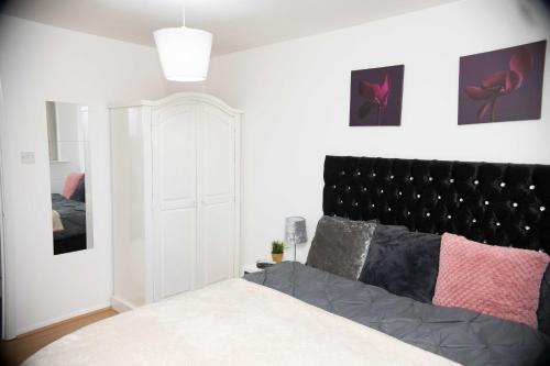 1 dormitorio con cama y cabecero negro en Emerald Apartments A star Proximity, en Londres