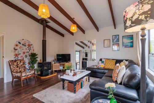 un soggiorno con un divano e un tavolo di Cozy Lake Retreat Lake Views & Amazing Games Room a Hamurana