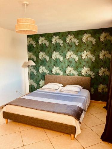 - une chambre dotée d'un lit avec un mur vert dans l'établissement Gite belle vue, à Olargues