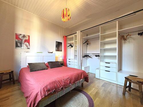 a bedroom with a bed with a red blanket at Charmante maison idéalement située - Eurythmie - 6 personnes - Jardin terrasse privés - Parking gratuit - 5 min à pied centre ville in Montauban