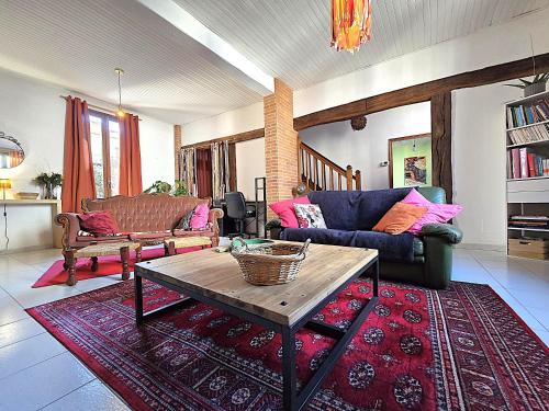 a living room with a couch and a table at Charmante maison idéalement située - Eurythmie - 6 personnes - Jardin terrasse privés - Parking gratuit - 5 min à pied centre ville in Montauban