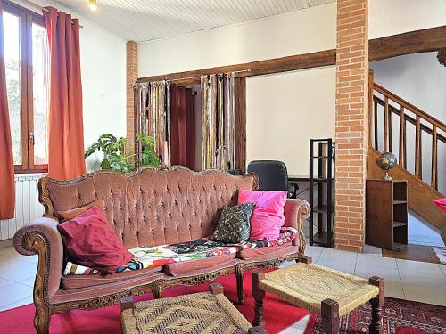 a living room with a couch with pillows on it at Charmante maison idéalement située - Eurythmie - 6 personnes - Jardin terrasse privés - Parking gratuit - 5 min à pied centre ville in Montauban