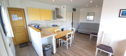 Il comprend une petite cuisine et une salle à manger avec une table. dans l'établissement Le petit fort, vue magnifique vue sur le port et la mer, à Dieppe