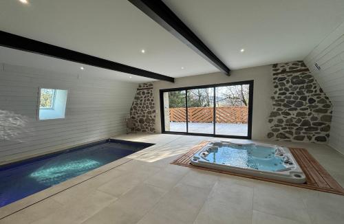 - une grande piscine dans une chambre dotée d'une grande fenêtre dans l'établissement La grange du pouget, à Polminhac