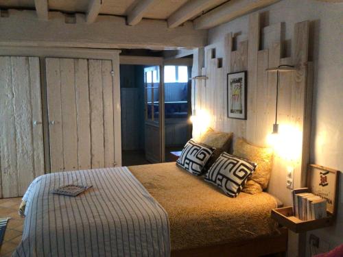 a bedroom with a bed with two pillows on it at La grotte du pèlerin - Appartement semi-troglodyte in Saintes
