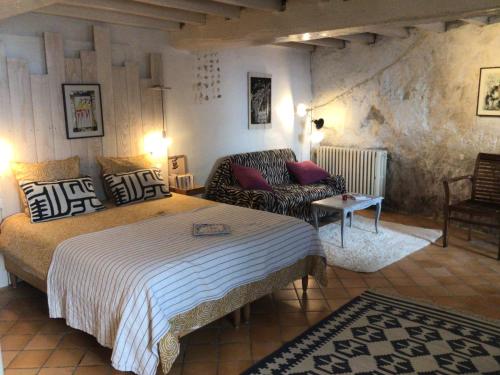 une chambre d'hôtel avec un lit et un canapé dans l'établissement La grotte du pèlerin - Appartement semi-troglodyte, à Saintes
