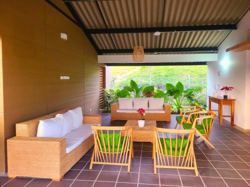 a patio with a couch and chairs and a table at Casa Campestre en zona exclusiva con Jacuzzi, a 10 min del aeropuerto, 20 min parque del café, WiFi, parqueadero privado, vigilancia 24 hrs y amplias zonas sociales in Armenia