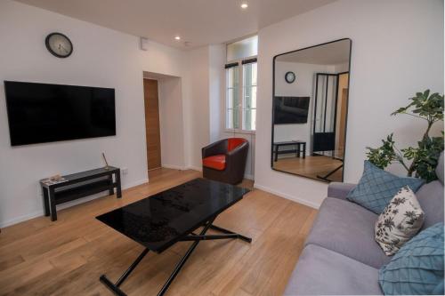 un salon avec un canapé, une table et un miroir dans l'établissement Merveilleux appartement - Proche de la Croisette !, à Cannes