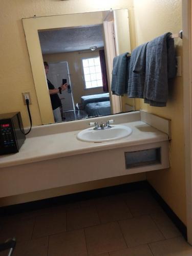 a person taking a picture of a bathroom mirror at 2 Double Beds Hotel Room 256 in Jackson